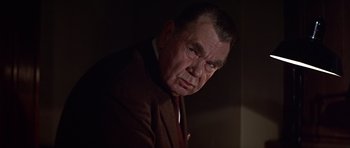 Movie still from “Funeral in Berlin” (1966), directed by Guy Hamilton – An older man wearing a suit and a tie; Close Up shot, Low angle