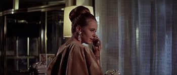 Movie still from “Funeral in Berlin” (1966), directed by Guy Hamilton – A woman talking on a phone while standing in front of a window; Close Up shot, Low angle