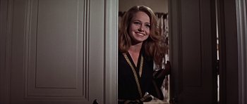 Movie still from “Funeral in Berlin” (1966), directed by Guy Hamilton – A woman in a black robe standing next to a door; Medium shot, Low angle