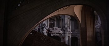 Movie still from “Funeral in Berlin” (1966), directed by Guy Hamilton – Two people walking up a staircase in a building; Extreme Wide shot, High angle