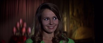Movie still from “Funeral in Berlin” (1966), directed by Guy Hamilton – A woman with long brown hair wearing a green shirt; Close Up shot, Low angle