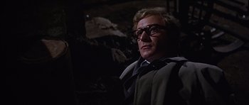 Movie still from “Funeral in Berlin” (1966), directed by Guy Hamilton – A person wearing glasses and a tie; Close Up shot, Low angle