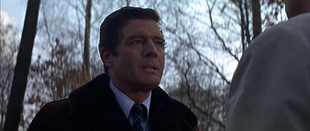 Movie still from “Funeral in Berlin” (1966), directed by Guy Hamilton – A person wearing a suit and tie; Close Up shot, Low angle