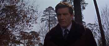 Movie still from “Funeral in Berlin” (1966), directed by Guy Hamilton – A person wearing a suit and tie; Close Up shot, Low angle