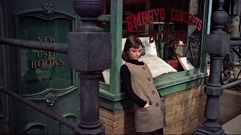 Movie still from “Funny Face” (1957), directed by Stanley Donen – A woman standing in front of a book store; Medium shot, High angle