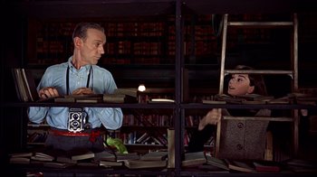 Movie still from “Funny Face” (1957), directed by Stanley Donen – A man and a woman are looking at books in a library; Medium shot, Low angle