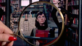 Movie still from “Funny Face” (1957), directed by Stanley Donen – A woman looking at herself in a mirror; Close Up shot, Over the shoulder angle