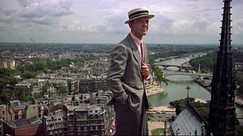 Movie still from “Funny Face” (1957), directed by Stanley Donen – A man standing on top of a tall building; Medium shot, Low angle