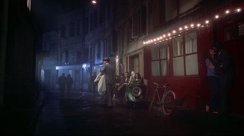 Movie still from “Funny Face” (1957), directed by Stanley Donen – A group of people sitting on the side of a building; Wide shot, High angle