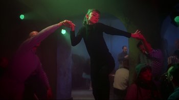Movie still from “Funny Face” (1957), directed by Stanley Donen – A woman in a black dress dancing in a green light; Medium shot, Low angle