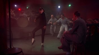 Movie still from “Funny Face” (1957), directed by Stanley Donen – A group of people dancing in a room with lights; Wide shot, Low angle