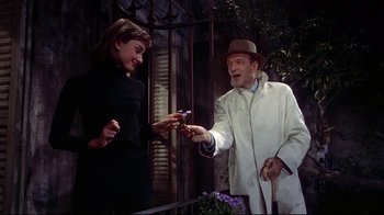 Movie still from “Funny Face” (1957), directed by Stanley Donen – A man and a woman are holding flowers and smiling; Medium shot, Low angle