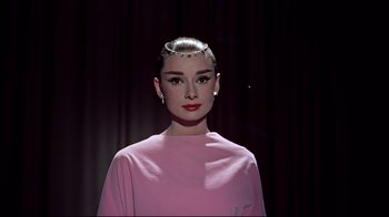 Movie still from “Funny Face” (1957), directed by Stanley Donen – A person wearing a pink shirt; Close Up shot, Low angle