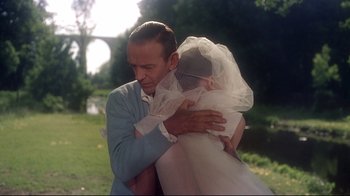 Movie still from “Funny Face” (1957), directed by Stanley Donen – A man and a woman hugging in a park; Medium shot, Over the shoulder angle