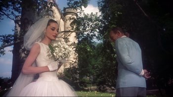 Movie still from “Funny Face” (1957), directed by Stanley Donen – A man and a woman standing in front of each other; Medium shot, Over the shoulder angle