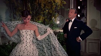 Movie still from “Funny Face” (1957), directed by Stanley Donen – A man and a woman dressed in formal wear; Medium shot, Low angle
