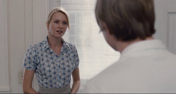 Movie still from “Funny Games” (2007), directed by Michael Haneke – A woman standing in front of a mirror looking at a man; Medium shot, Over the shoulder angle