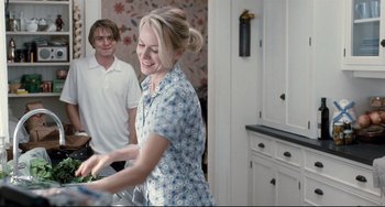 Movie still from “Funny Games” (2007), directed by Michael Haneke – Two people in a kitchen , one of whom is holding a bowl of food; Medium shot, Over the shoulder angle