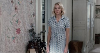 Movie still from “Funny Games” (2007), directed by Michael Haneke – A woman standing in front of a bunch of golf clubs; Medium shot, Over the shoulder angle