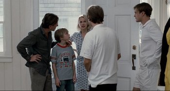Movie still from “Funny Games” (2007), directed by Michael Haneke – A group of people standing in front of a door; Medium shot, Over the shoulder angle