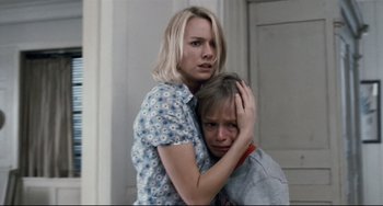 Movie still from “Funny Games” (2007), directed by Michael Haneke – A woman hugging another woman while she is holding her head; Close Up shot, Low angle
