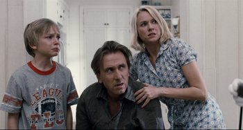 Movie still from “Funny Games” (2007), directed by Michael Haneke – A group of people standing next to each other in a room; Medium shot, Low angle