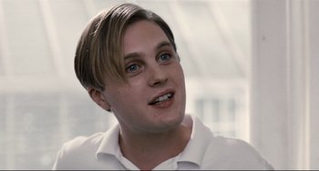 Movie still from “Funny Games” (2007), directed by Michael Haneke – A person wearing a white shirt; Close Up shot, Over the shoulder angle