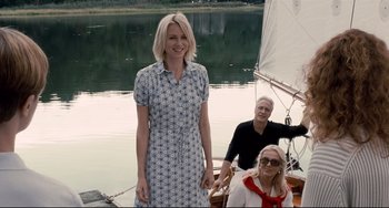 Movie still from “Funny Games” (2007), directed by Michael Haneke – A woman standing next to two other people on a boat; Medium shot, Low angle