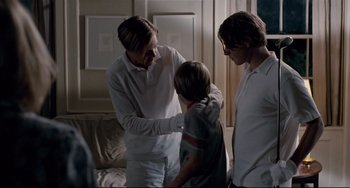 Movie still from “Funny Games” (2007), directed by Michael Haneke – A woman and two men standing next to a child; Medium shot, Over the shoulder angle