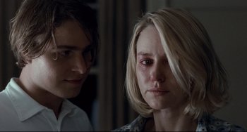 Movie still from “Funny Games” (2007), directed by Michael Haneke – Two people looking at each other in a dark room; Close Up shot, Over the shoulder angle