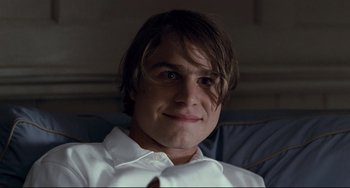 Movie still from “Funny Games” (2007), directed by Michael Haneke – A man with long brown hair wearing a white shirt; Close Up shot, Over the shoulder angle