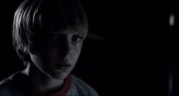 Movie still from “Funny Games” (2007), directed by Michael Haneke – A young boy is staring into the dark; Close Up shot, Over the shoulder angle