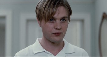 Movie still from “Funny Games” (2007), directed by Michael Haneke – A person wearing a white shirt; Close Up shot, Low angle