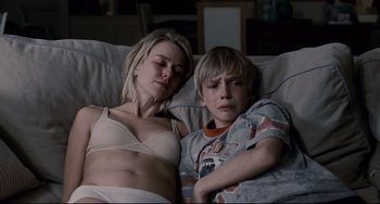 Movie still from “Funny Games” (2007), directed by Michael Haneke – A woman and a boy laying in a bed together; Medium shot, Low angle