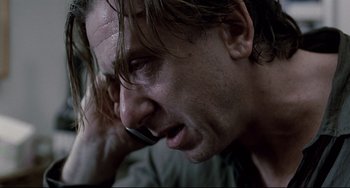 Movie still from “Funny Games” (2007), directed by Michael Haneke – A person talking on a cell phone; Close Up shot, Low angle