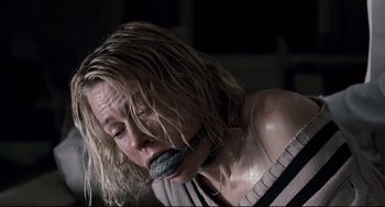 Movie still from “Funny Games” (2007), directed by Michael Haneke – A woman with her mouth taped shut and wet hair; Close Up shot, High angle