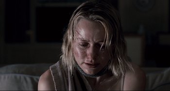 Movie still from “Funny Games” (2007), directed by Michael Haneke – A young woman with wet hair and a necklace; Close Up shot, Low angle