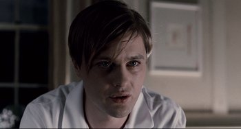 Movie still from “Funny Games” (2007), directed by Michael Haneke – A person wearing a white shirt; Close Up shot, Over the shoulder angle