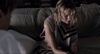 Movie still from “Funny Games” (2007), directed by Michael Haneke – A woman sitting on top of a couch looking down; Close Up shot, High angle