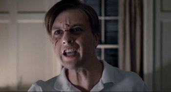 Movie still from “Funny Games” (2007), directed by Michael Haneke – A man with a bloody nose and mouth is looking angry; Close Up shot, Low angle