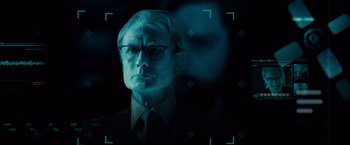 Movie still from “G-Force” (2009), directed by Hoyt Yeatman – A man in a suit and tie with glasses; Close Up shot, Over the shoulder angle