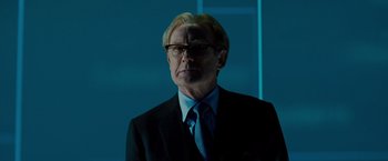 Movie still from “G-Force” (2009), directed by Hoyt Yeatman – A man in a suit and tie standing in front of a wall; Close Up shot, Low angle