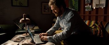 Movie still from “G-Force” (2009), directed by Hoyt Yeatman – A man sitting in front of an open laptop computer; Medium shot, Low angle