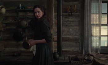 Movie still from “The World to Come” (2020), directed by Mona Fastvold – A woman holding a pan in a kitchen; Medium shot, Over the shoulder angle