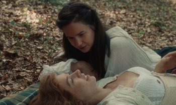 Movie still from “The World to Come” (2020), directed by Mona Fastvold – Two women are laying on the ground in the leaves; Close Up shot, High angle
