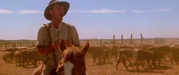 Movie still from “Gallipoli” (1981), directed by Peter Weir – A man on a horse in the middle of a herd of cattle; Medium shot, Low angle