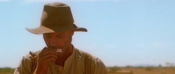 Movie still from “Gallipoli” (1981), directed by Peter Weir – A man wearing a cowboy hat brushing his teeth; Close Up shot, Low angle