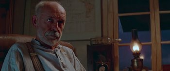 Movie still from “Gallipoli” (1981), directed by Peter Weir – An older man sitting in front of a clock; Close Up shot, Low angle