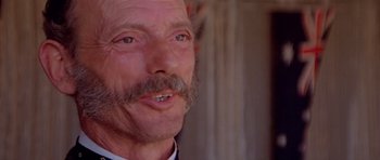 Movie still from “Gallipoli” (1981), directed by Peter Weir – An older man with a mustache and a mustache comb; Close Up shot, Low angle
