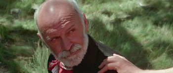 Movie still from “Gallipoli” (1981), directed by Peter Weir – An older man with a beard and a red neck tie; Close Up shot, Low angle